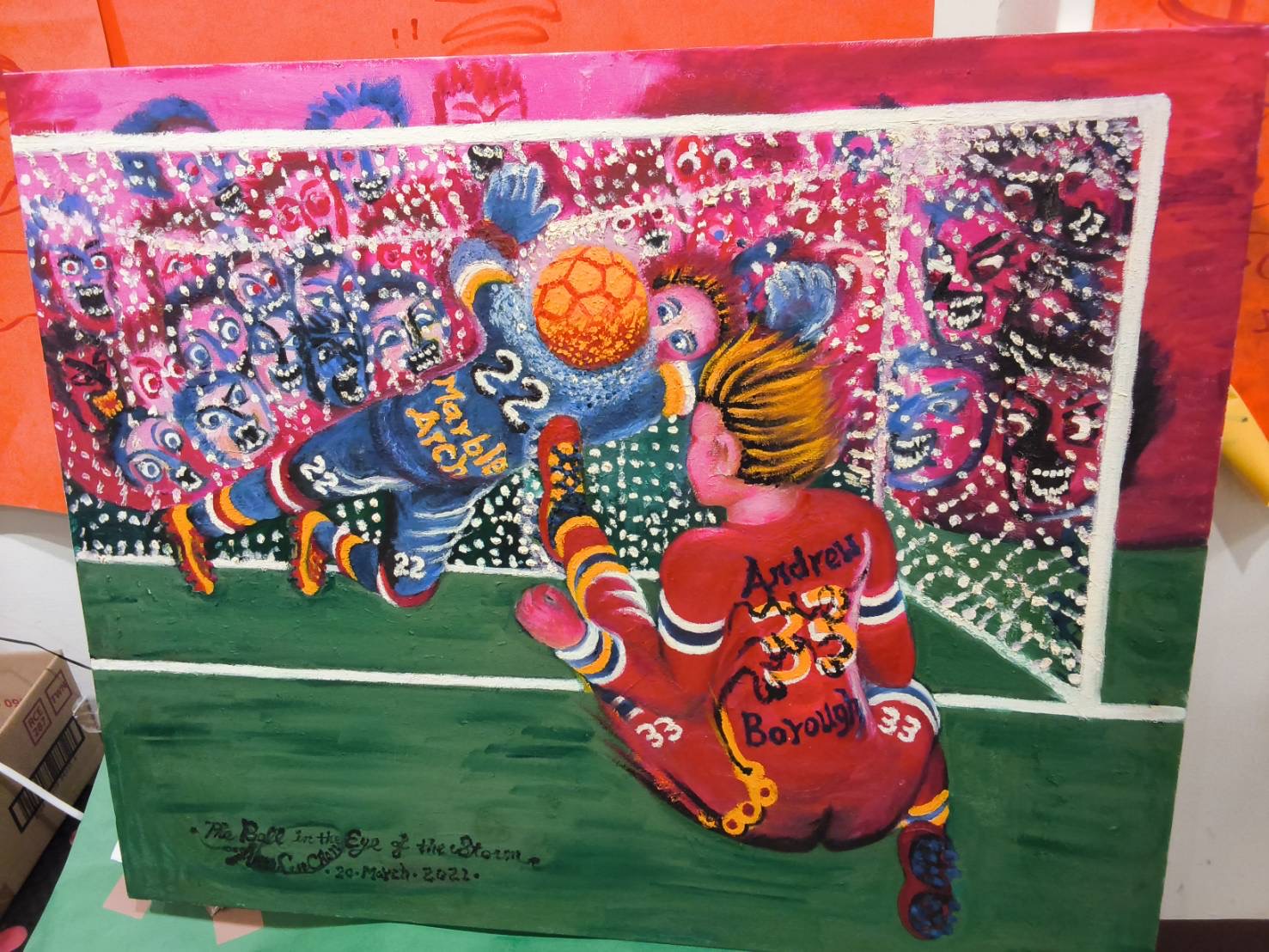 A vivid football scene with players, a ball and a crowd, including hand-painted lettering